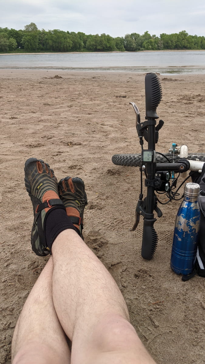 Mann macht Pause vom Fahrradfahren am Rheinufer